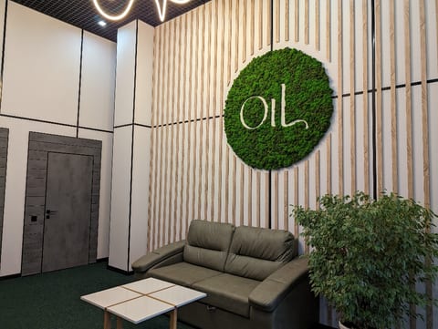 Зона отдыха салона с диваном и логотипом OiL из мха